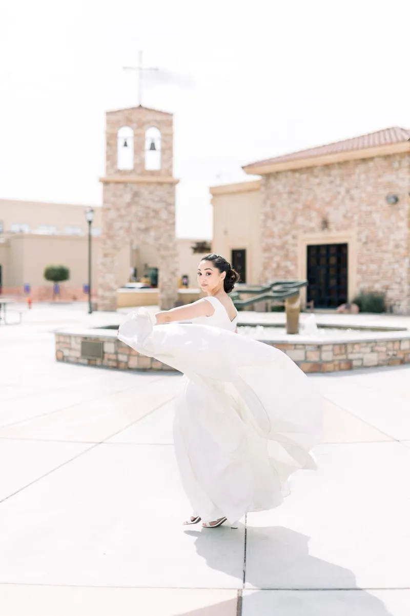 Bride spinning her gown across the wide paved plaza beside the fountain