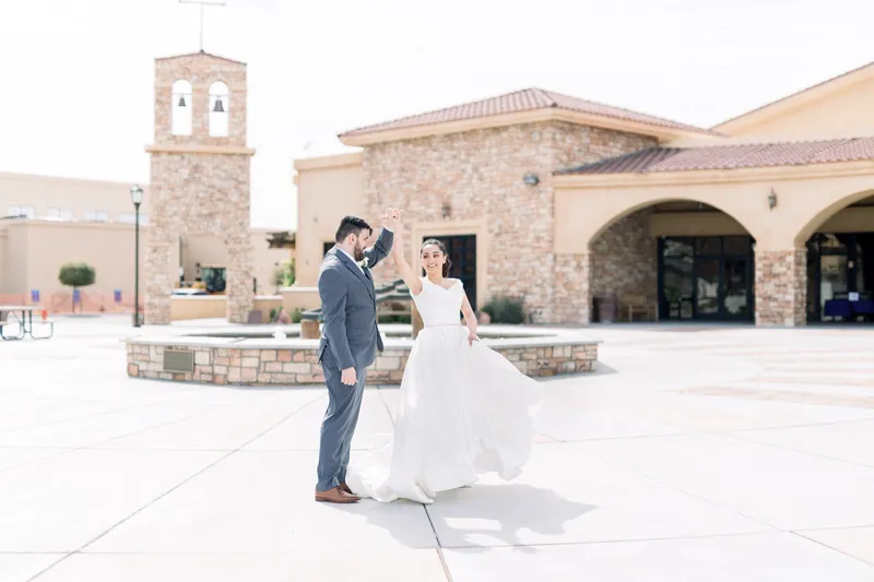 Groom turning the bride in the middle of the plaza, her skirt swinging out toward the fountain