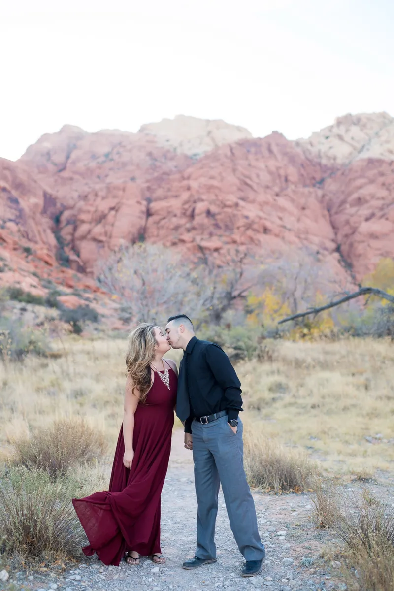 Couple kissing in front of the red cliffs at Red Rock Canyon