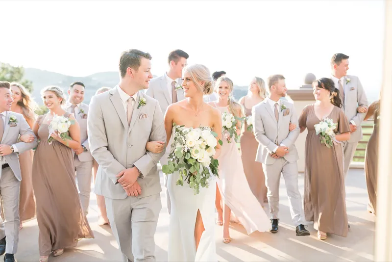 Wedding party walking the length of the terrace together with the couple in the middle of the group