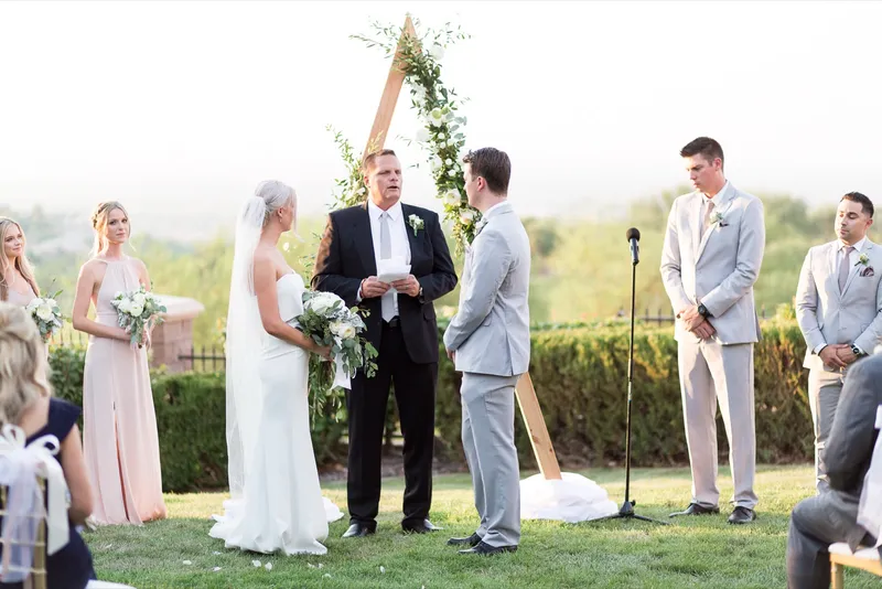 Couple facing the officiant with the bridesmaids lined up on one side and the groomsmen on the other