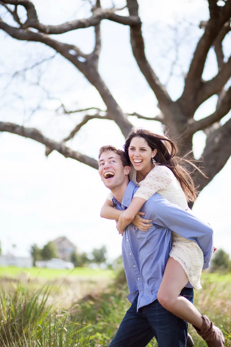 Couple laughing mid embrace during a desert engagement session