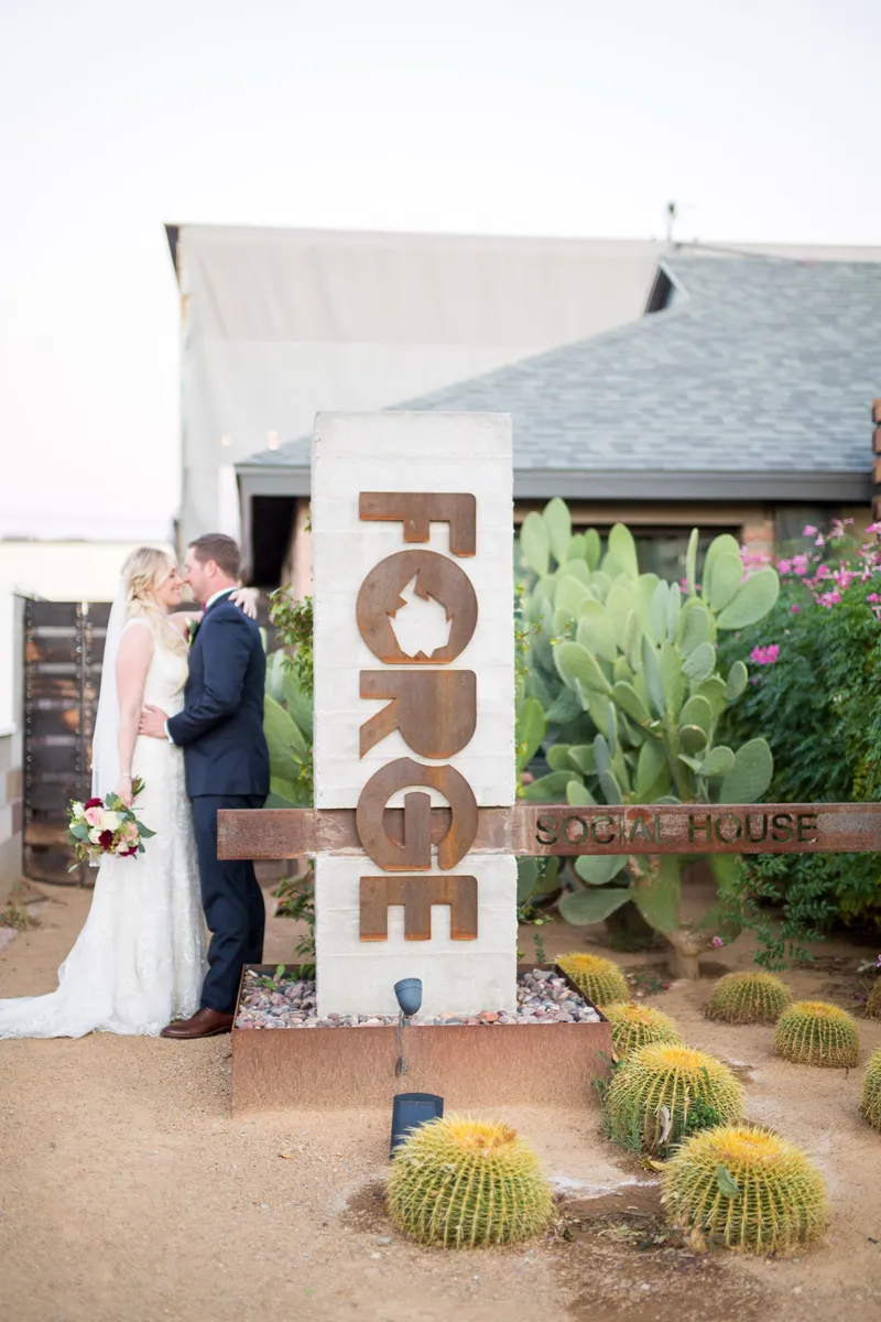 Couple kissing in front of The Forge sign in Boulder City, Nevada