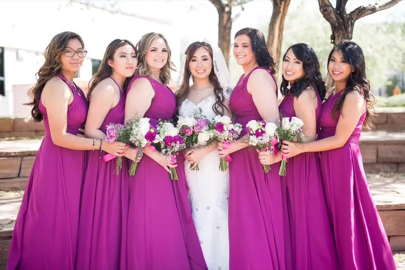 Bride and bridesmaids pressed close together with their bouquets held up in front of them