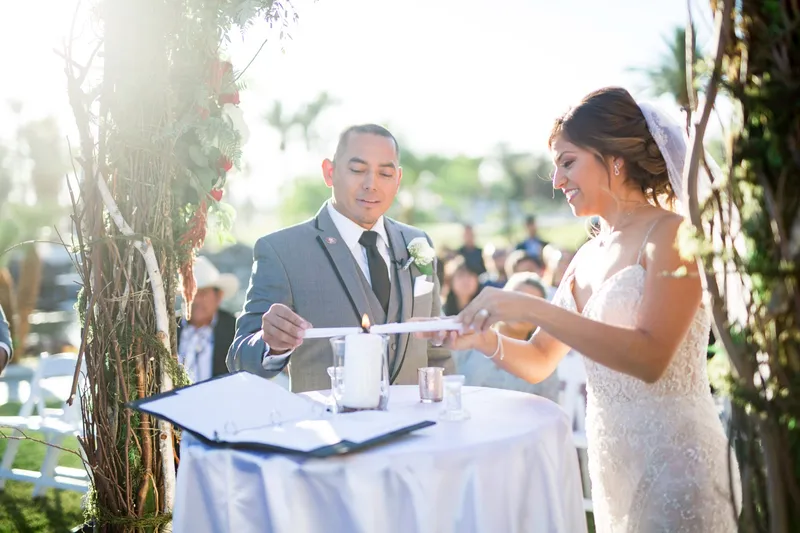 Bride and groom leaning in together to light the unity candle during the ceremony