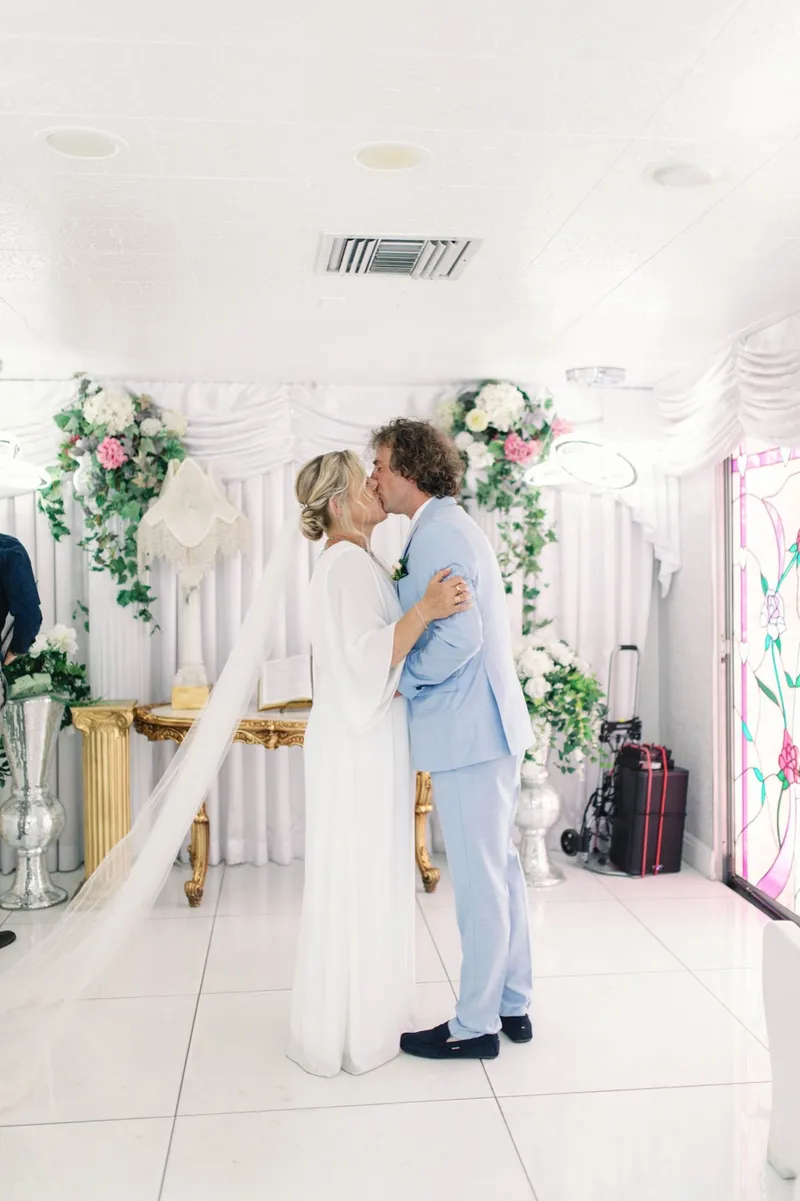 First kiss at the flower covered altar inside the chapel