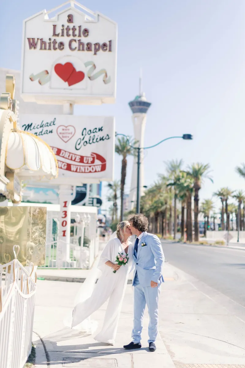 Couple standing under the chapel's drive up wedding window sign on the street