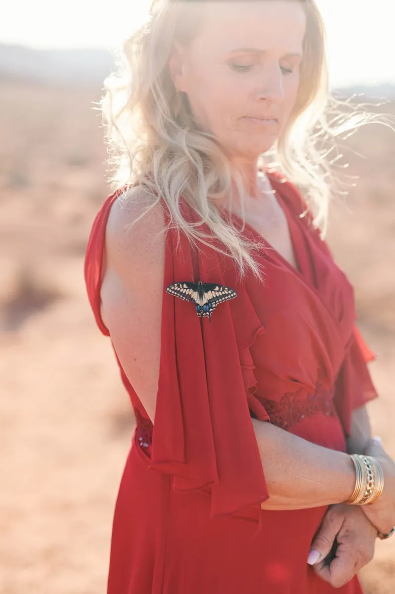 Close view of a guest in a deep red dress with beaded detail at the shoulder