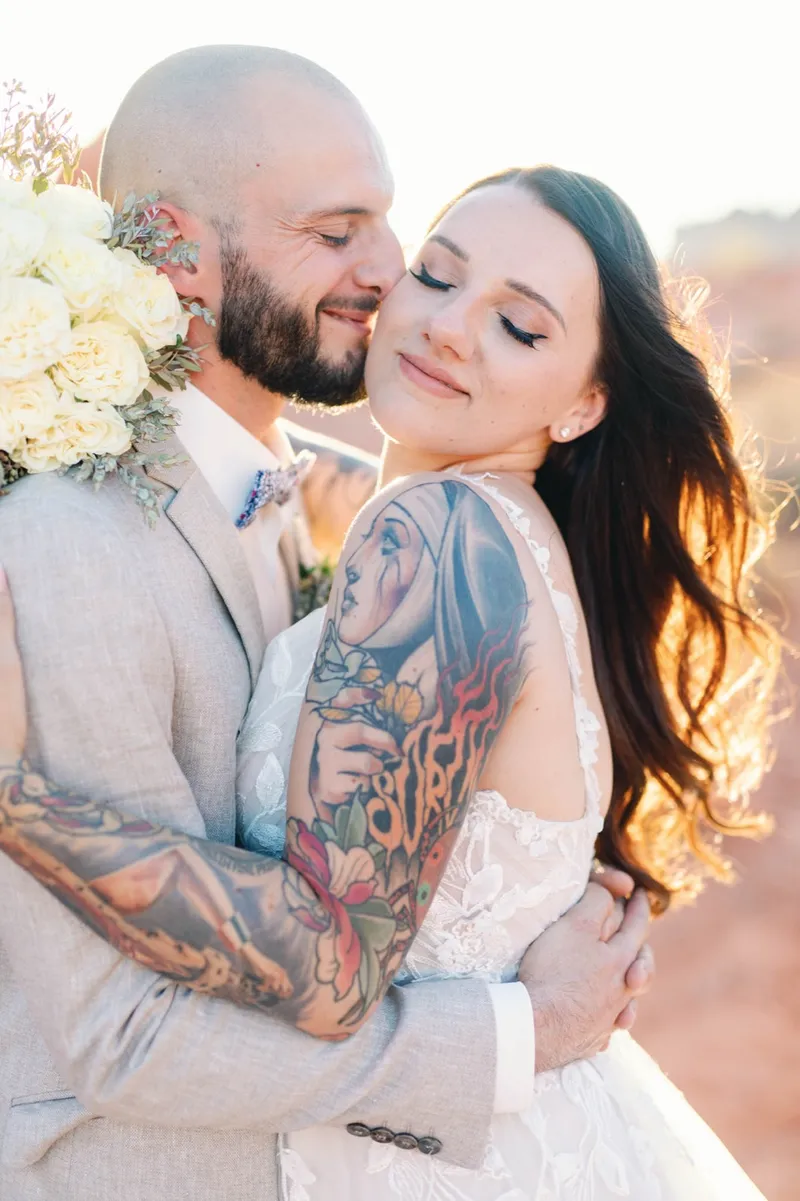 Bride resting back against her groom with her eyes closed in the warm light
