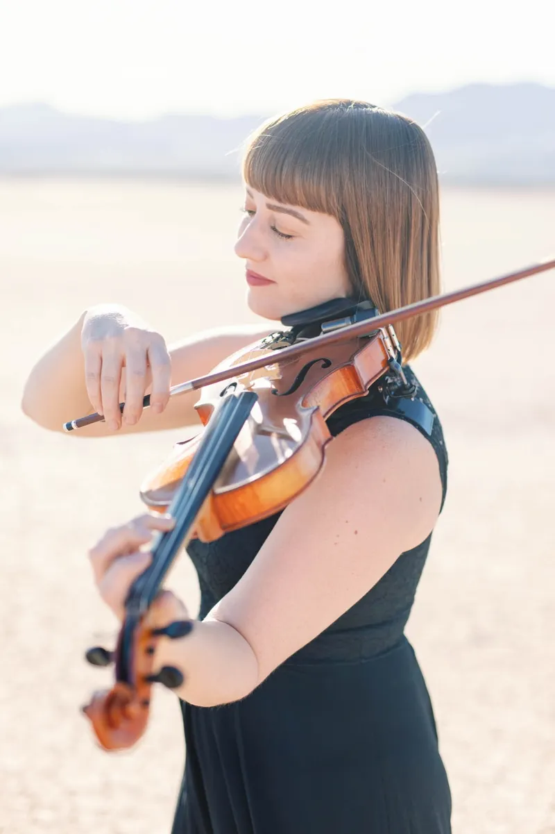 Close view of the violinist mid bow as she plays during the ceremony
