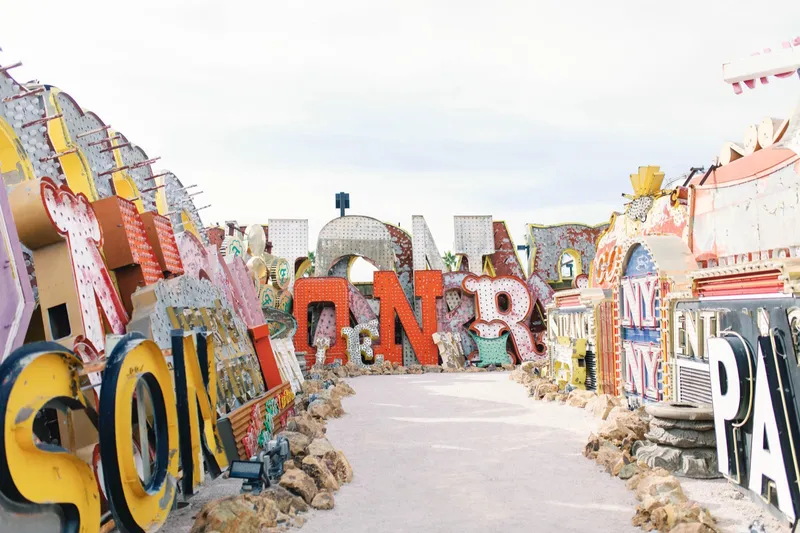 A narrow path winding between towering salvaged neon signs