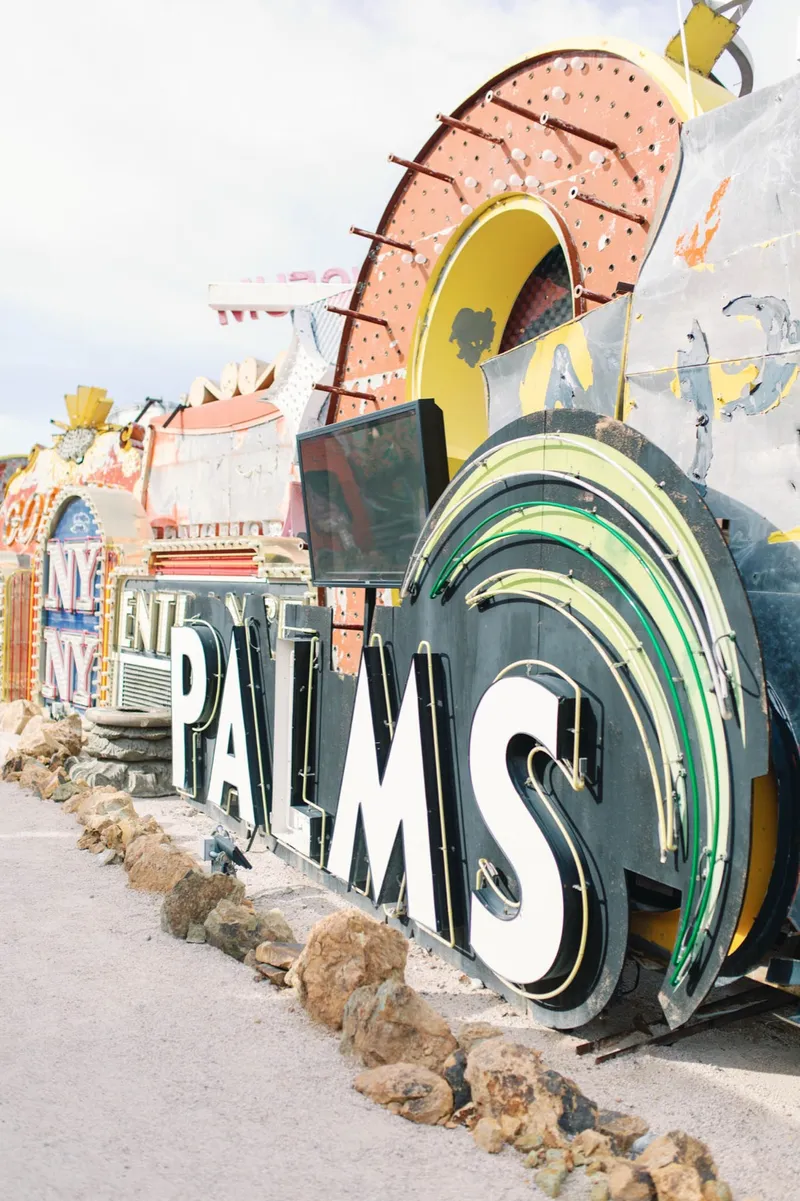 The Palms sign and a curved neon sweep among the other salvaged signs