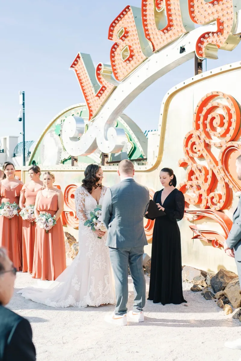 Ceremony in progress with the wedding party standing on both sides among the signs