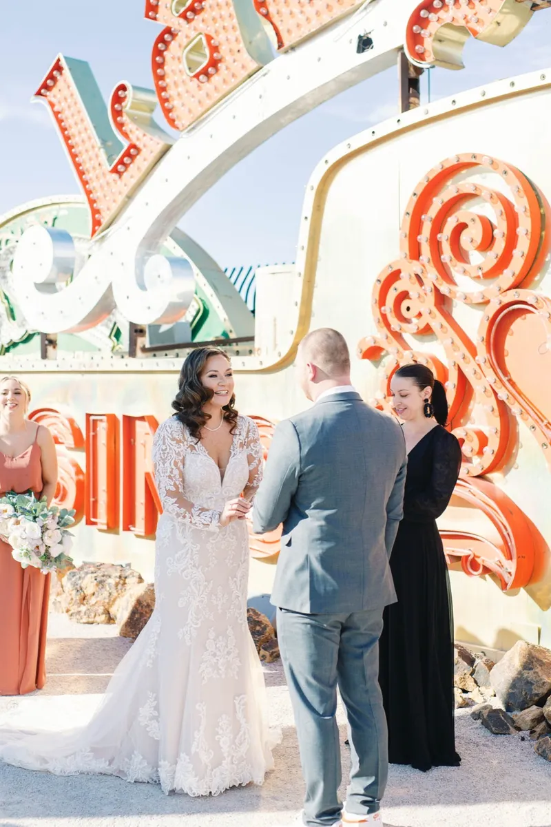 Bride and groom exchanging rings while the officiant reads beside them
