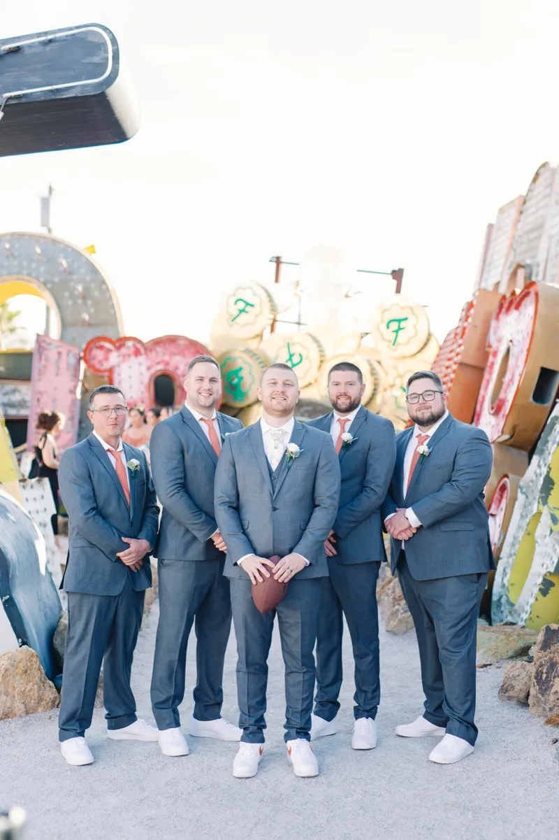 Groom and his groomsmen in blue suits lined up in front of the old casino signs