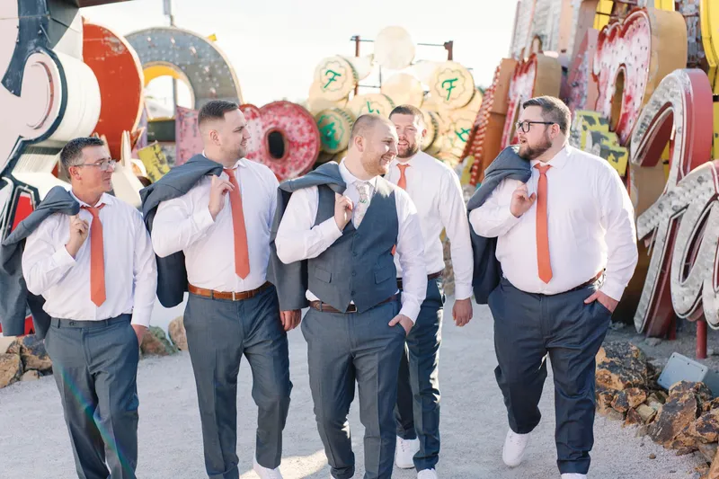 Groomsmen walking the boneyard path with jackets over their shoulders