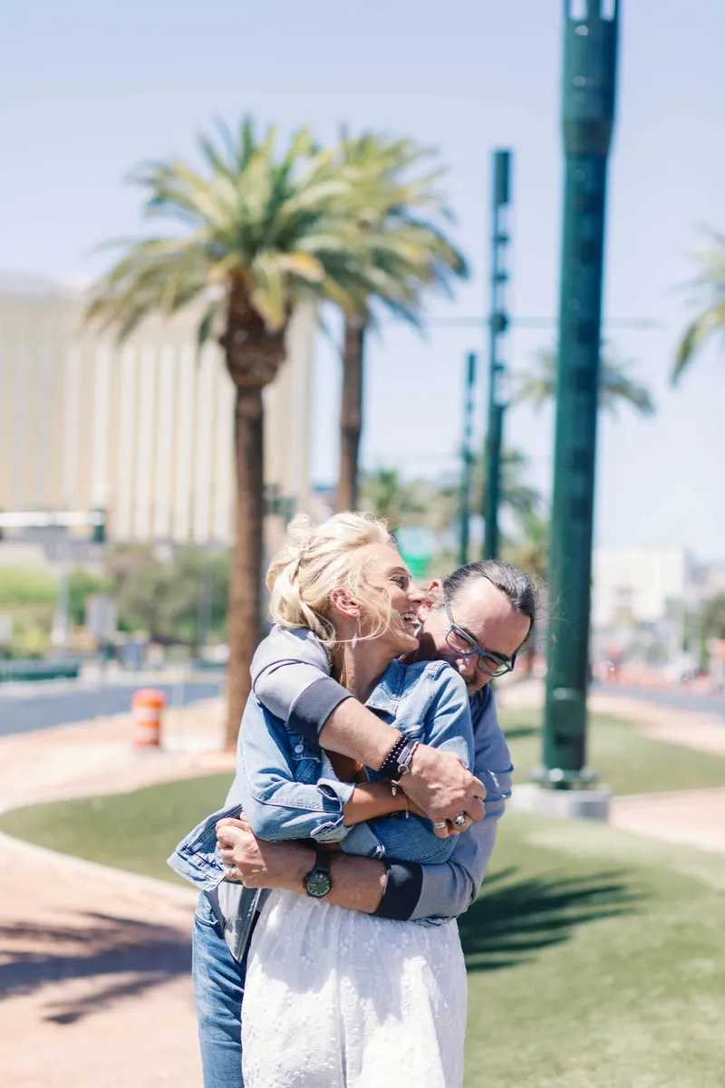 Groom lifting his bride into a kiss on the grass under the palms