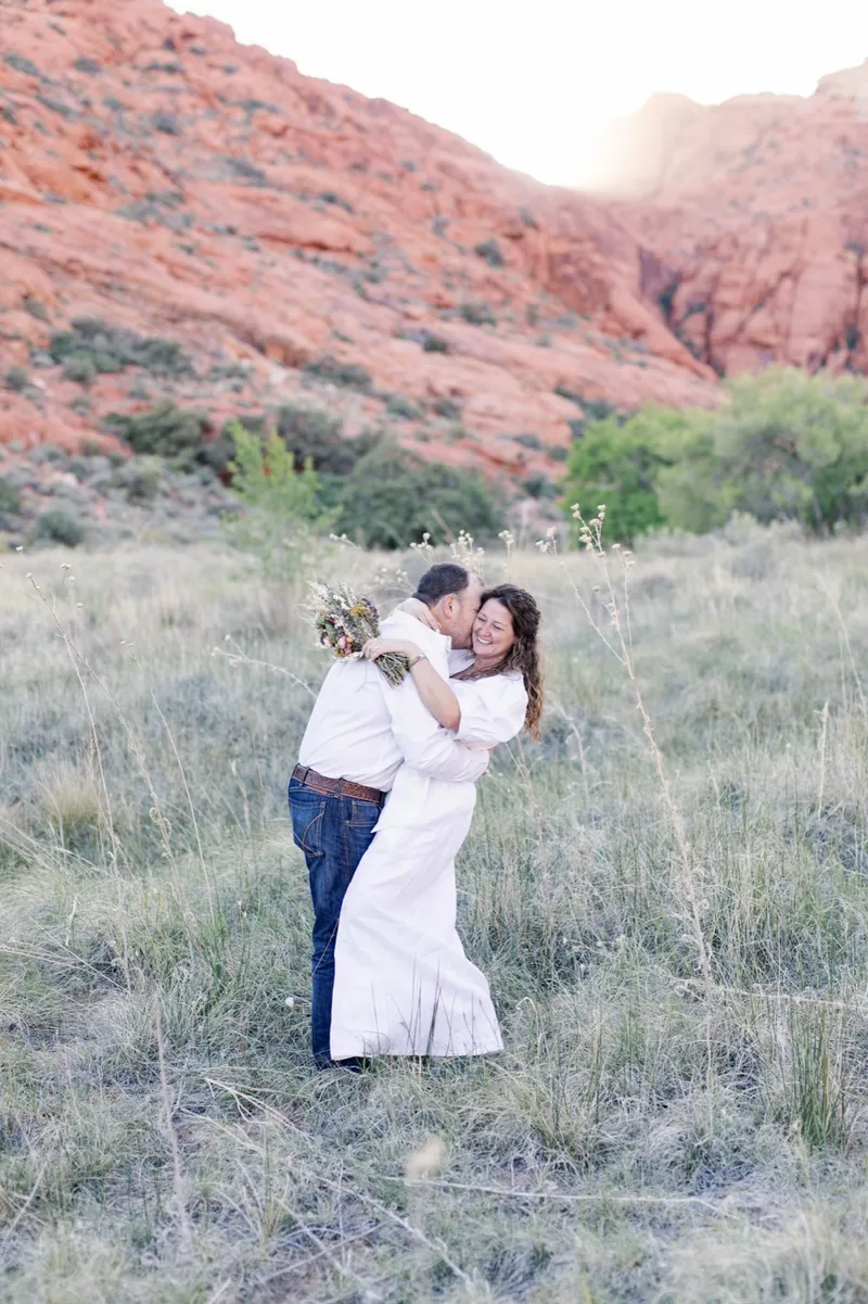 Bride resting her forehead against her grooms as she holds her bouquet at his shoulder