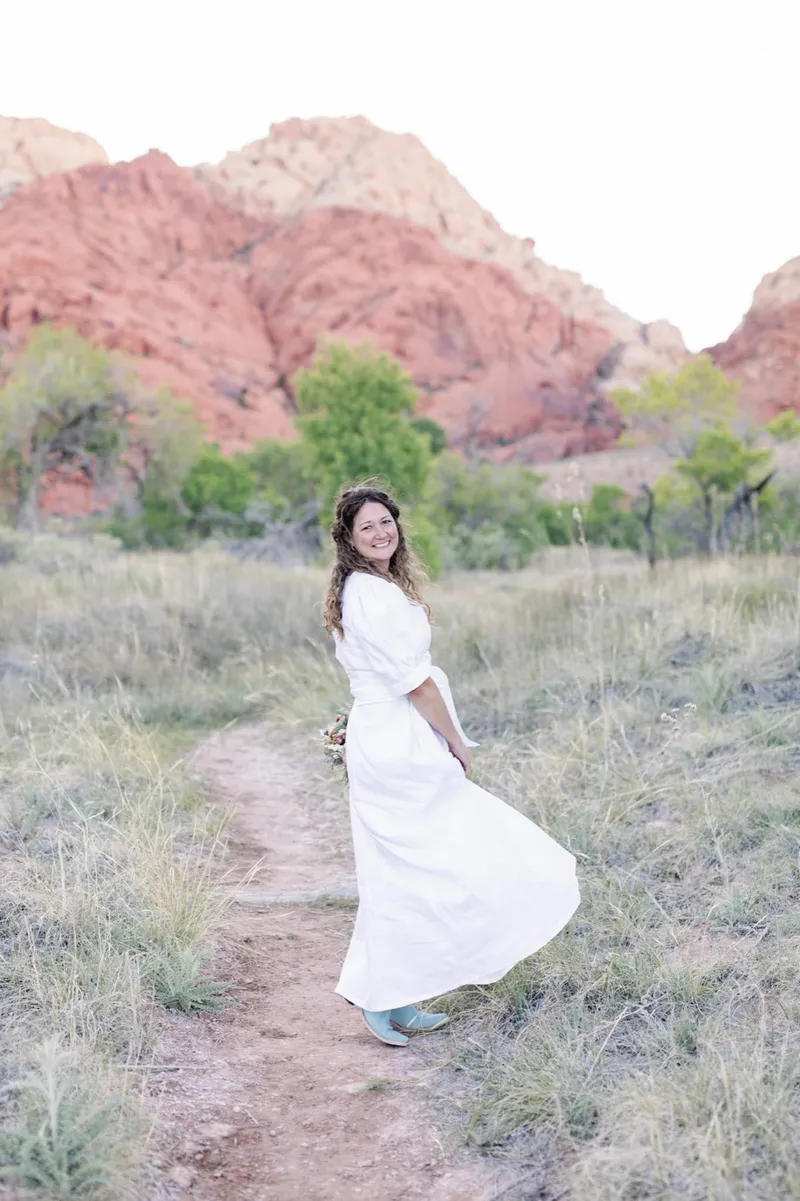 Bride walking a desert path alone with her skirt swinging out behind her