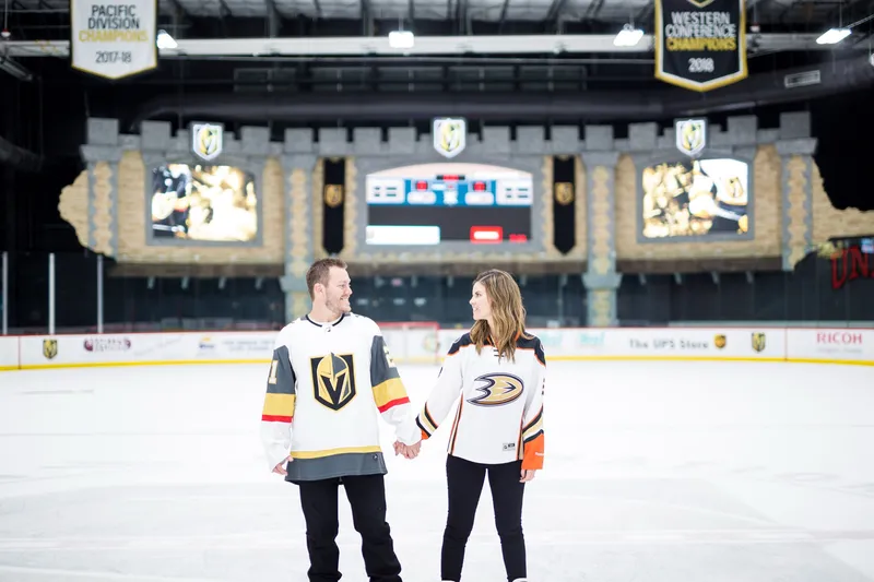 Engaged couple in hockey jerseys at the Vegas Golden Knights arena
