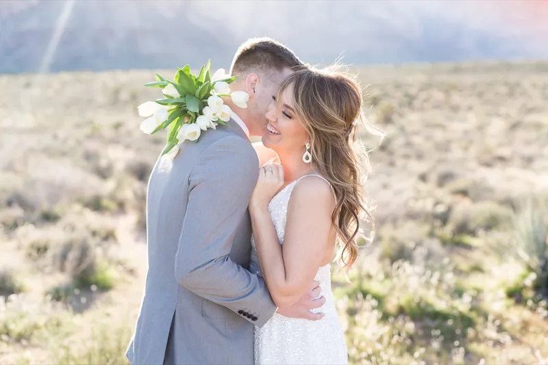 Bride and groom laughing together with her tulip bouquet between them