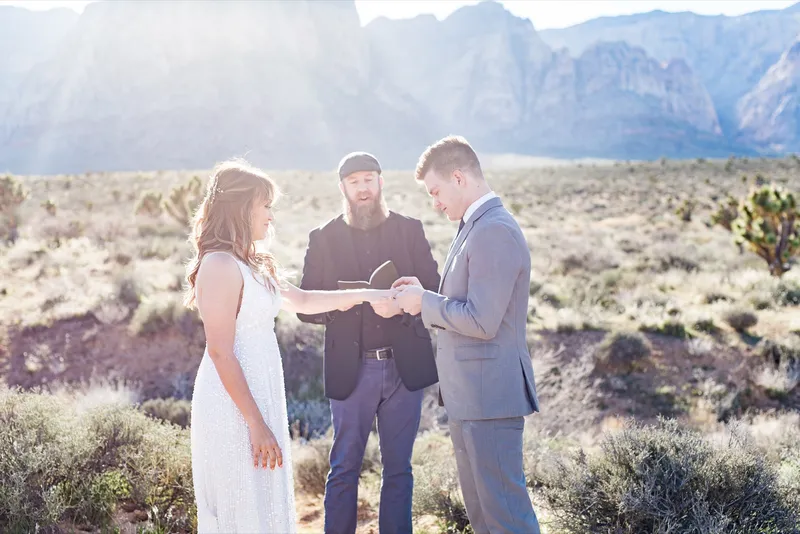 Close moment of the ring exchange with the officiant guiding them through it