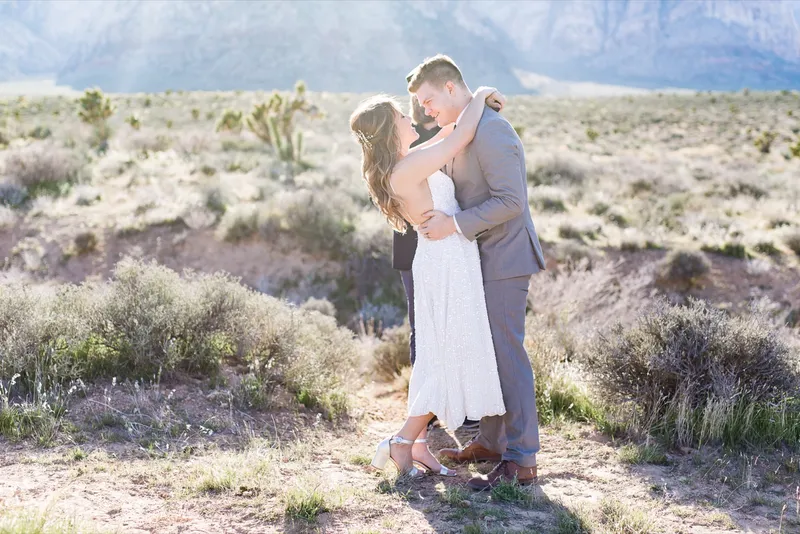 Couple kissing at the end of their ceremony in the open desert