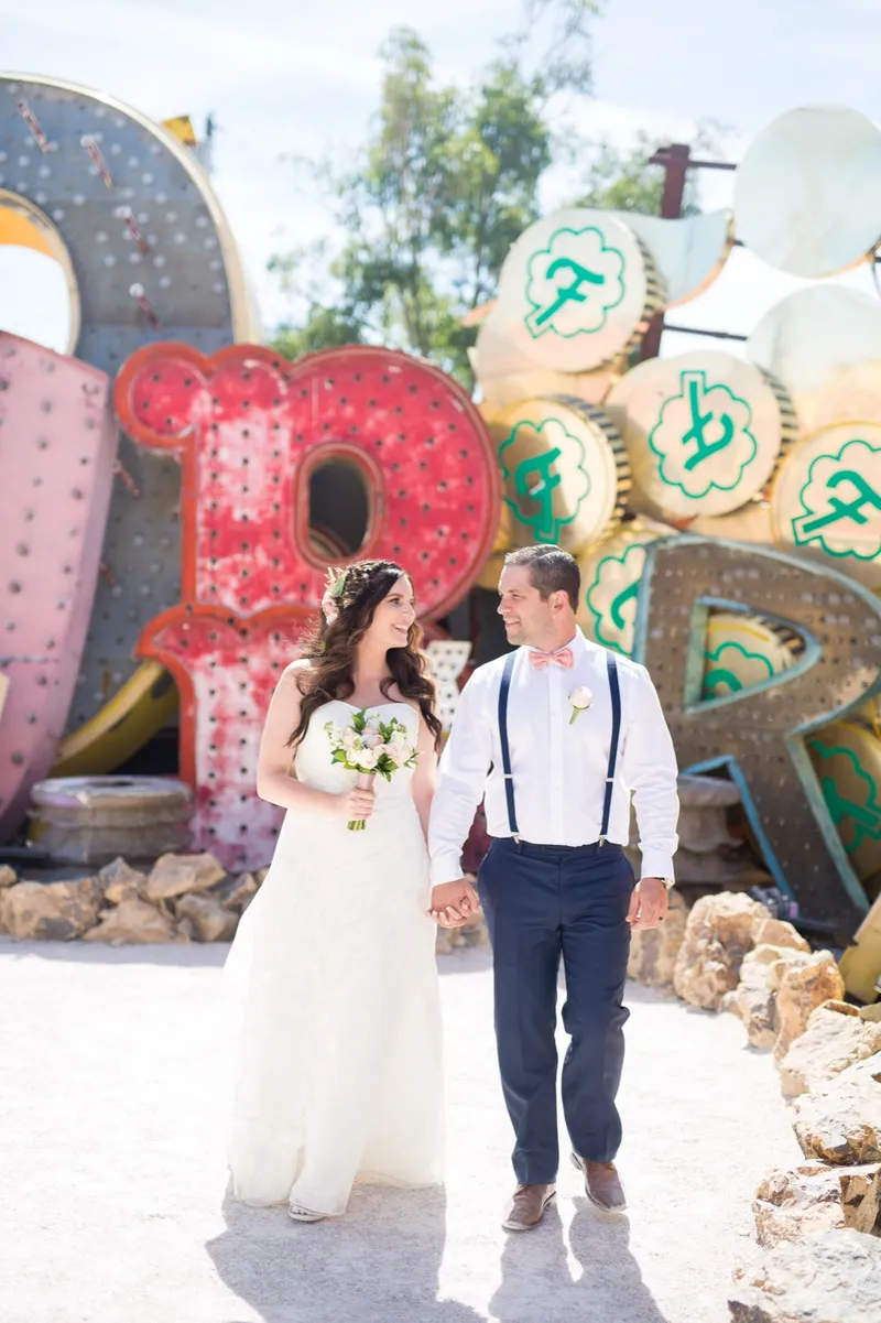 Bride and groom walking hand in hand past a big red letter R and gold coins