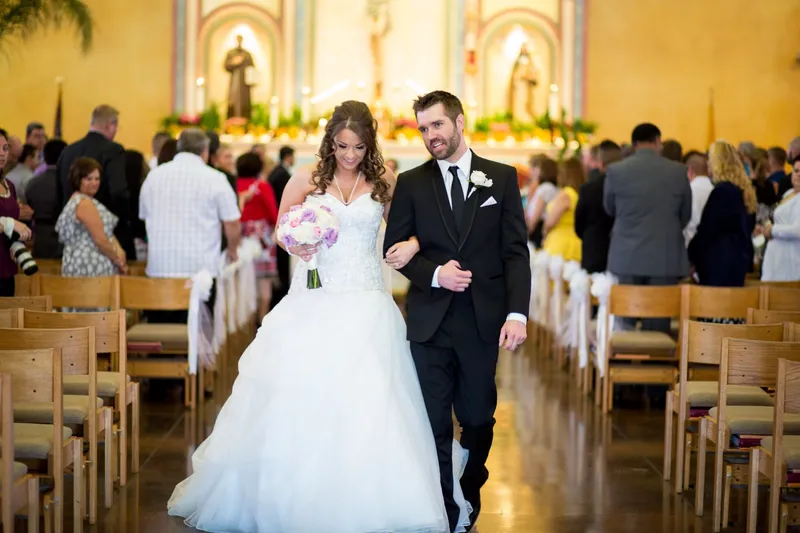 The couple walking back down the aisle together after the ceremony with guests turned toward them