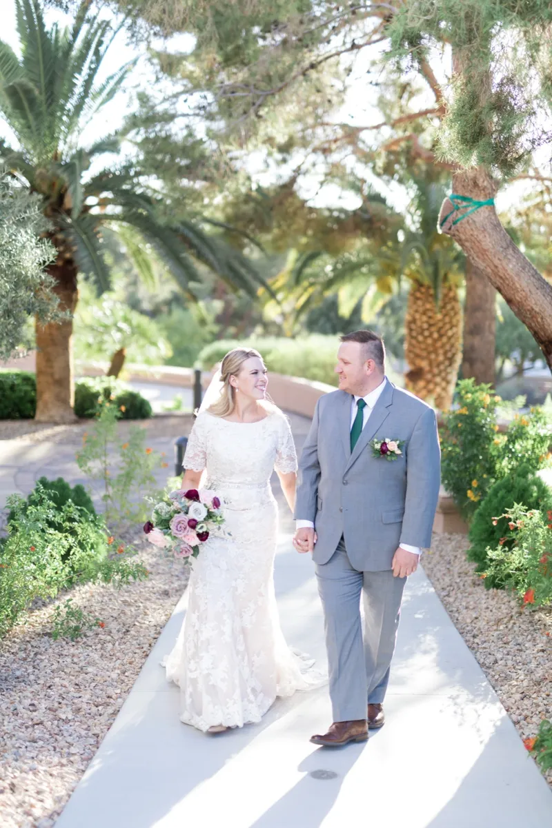 The couple walking hand in hand down the path, leaning in toward each other as they go