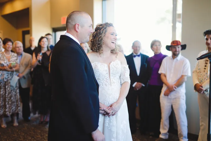 Couple standing close together in the middle of a crowd of guests just after the ceremony