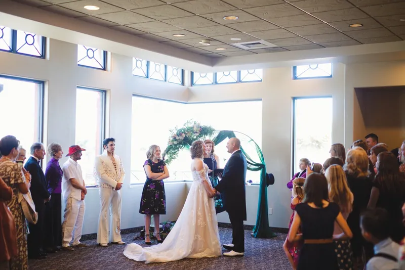 Indoor ceremony with an Elvis performer standing in for the officiant and guests watching from their chairs