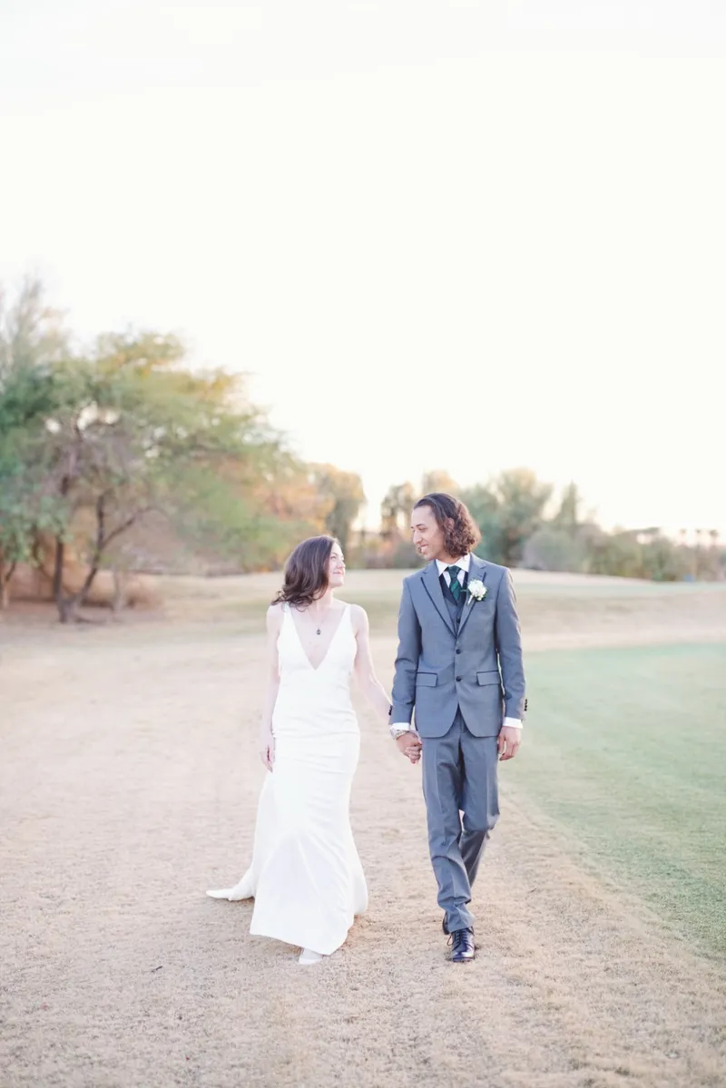 Couple walking the cart path toward the camera, both of them laughing