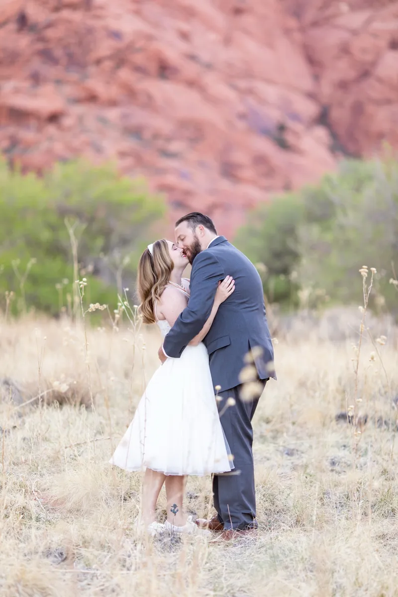 Bride and groom kissing in front of the red cliffs at Red Rock Canyon near Las Vegas