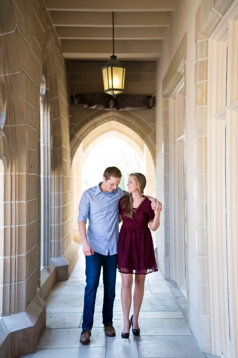 Couple laughing together under stone arches