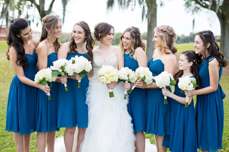 Bride and groom laughing with their bridal party on a wedding day