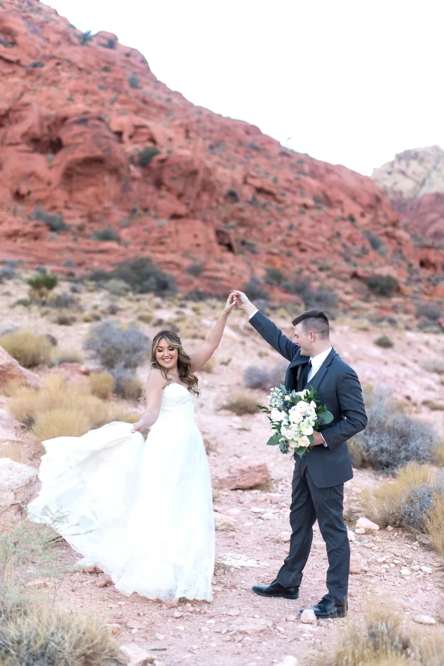 Groom spinning his bride in front of the red rocks at Valley of Fire