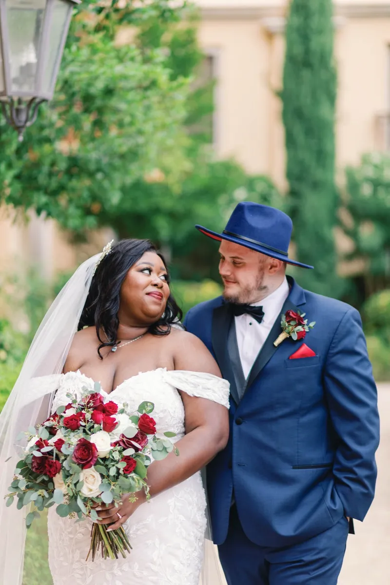 Close portrait of the couple with the bride's red bouquet up between them