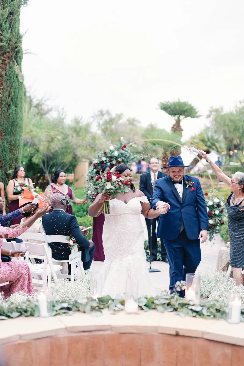 Couple coming back up the aisle together as guests cheer from both sides