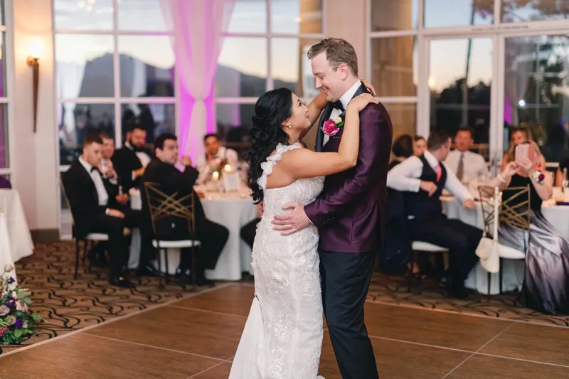 Couple holding each other on the dance floor as the room looks on