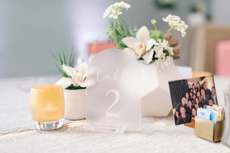 Table two marker with succulents, white blooms and a framed photo of the couple