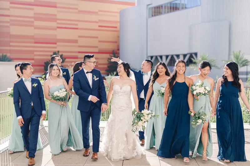 Full wedding party walking side by side with the bride and groom in the middle