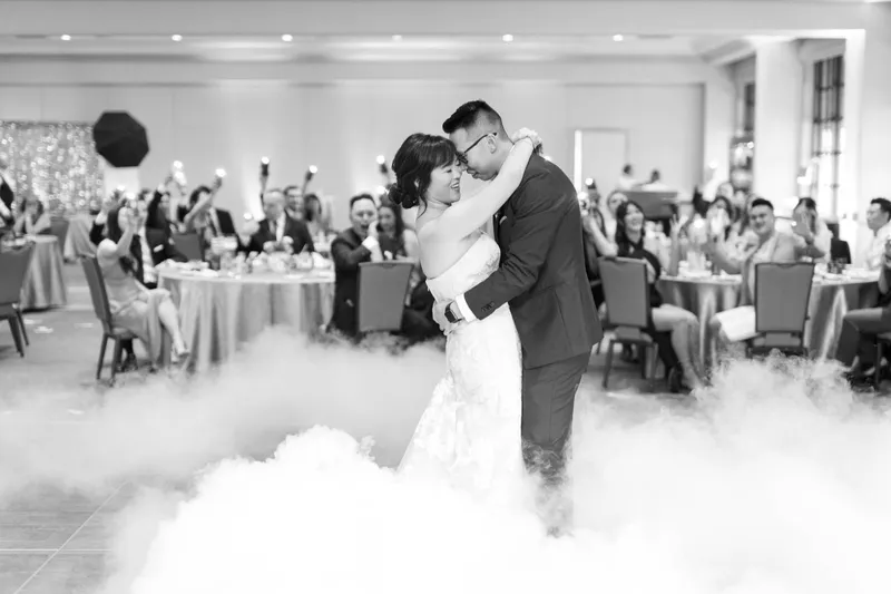 Black and white frame of the first dance with the fog banked around their feet