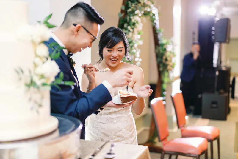Bride and groom feeding each other the first bite of cake