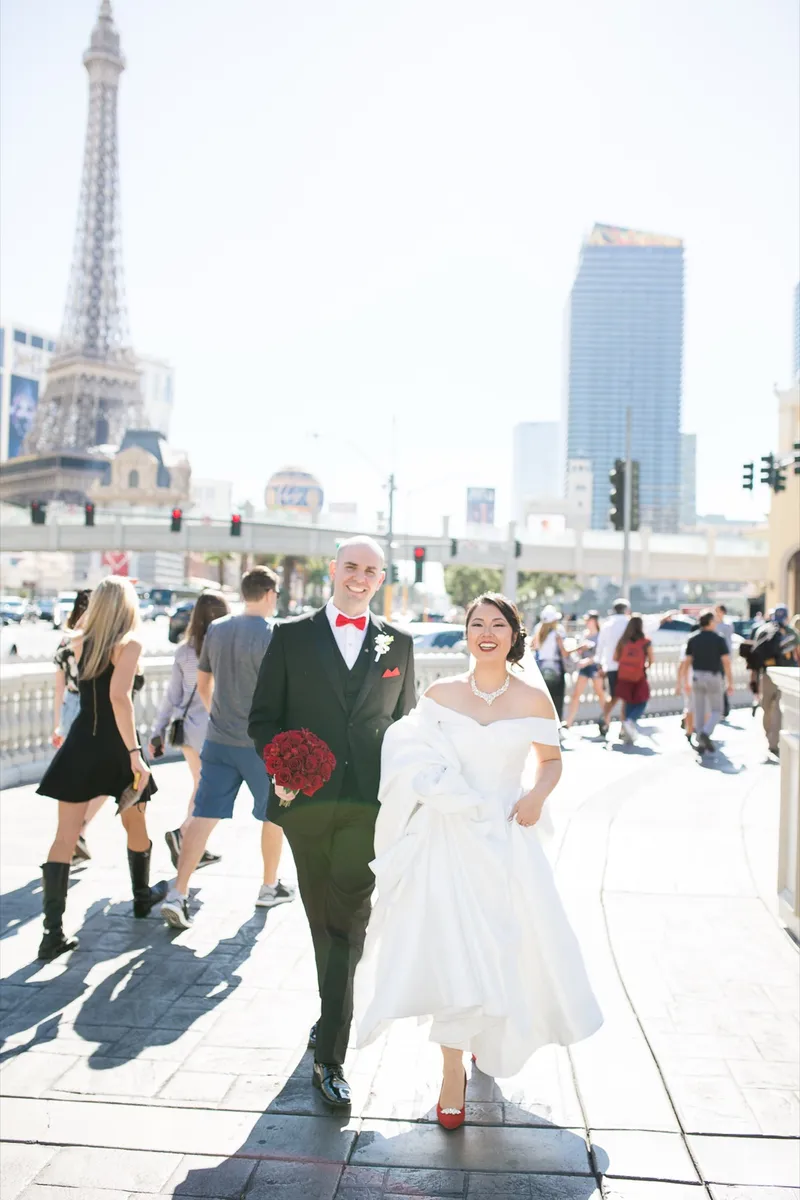 Bride and groom walking the Las Vegas Boulevard sidewalk in the middle of the afternoon crowd