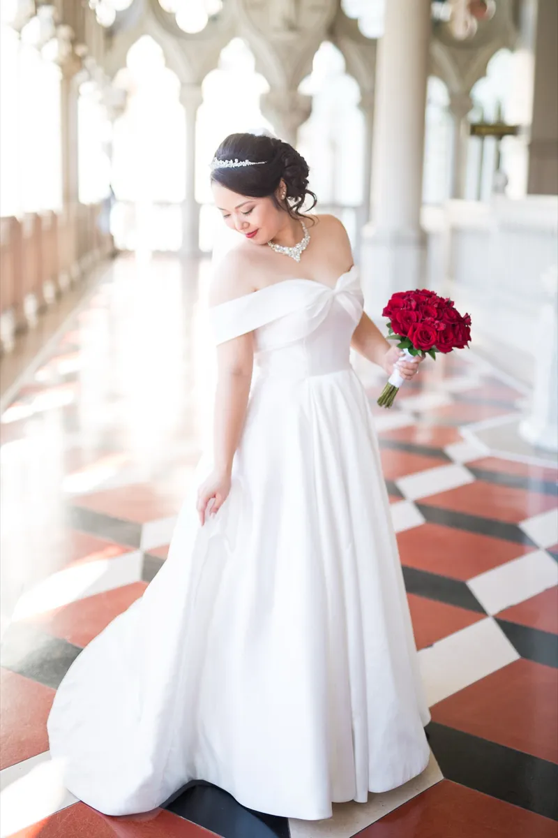 Bride mid step on the checkered marble floor, the skirt of her satin gown swinging out to one side