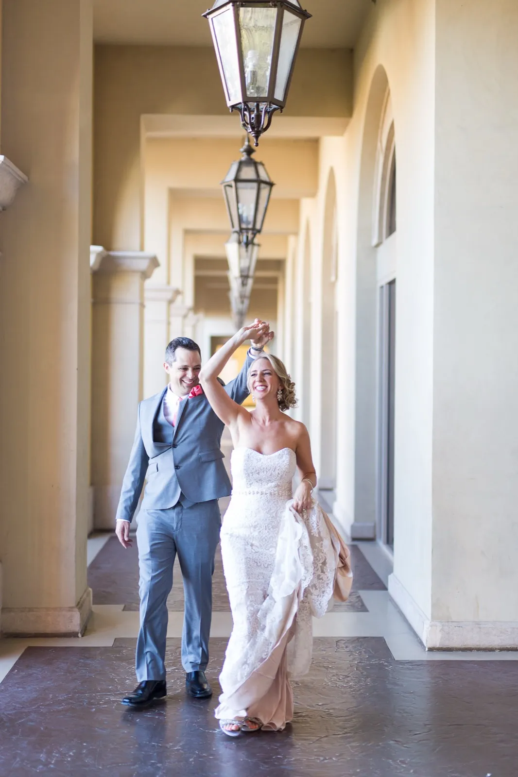 Groom twirls his bride under hanging lanterns in the village’s long covered arcade walkway