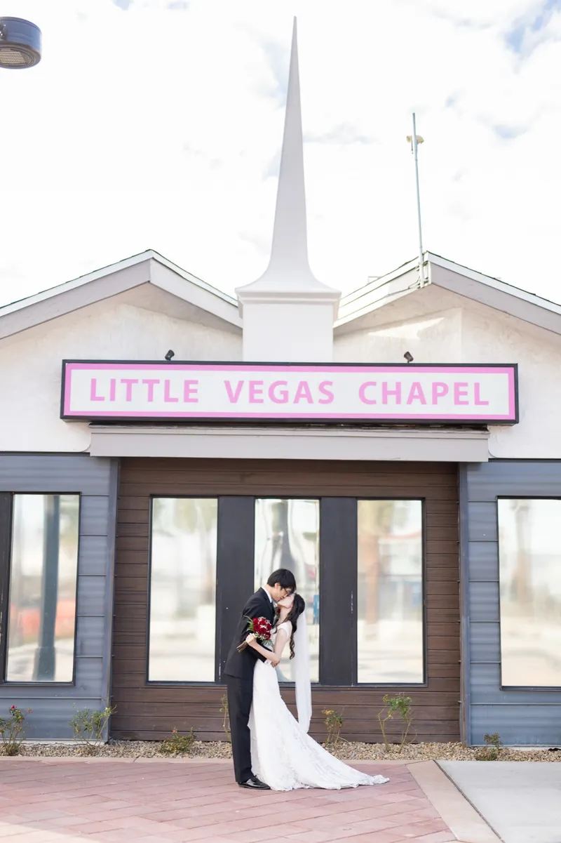 Groom dipping his bride for a kiss under the Little Vegas Chapel marquee