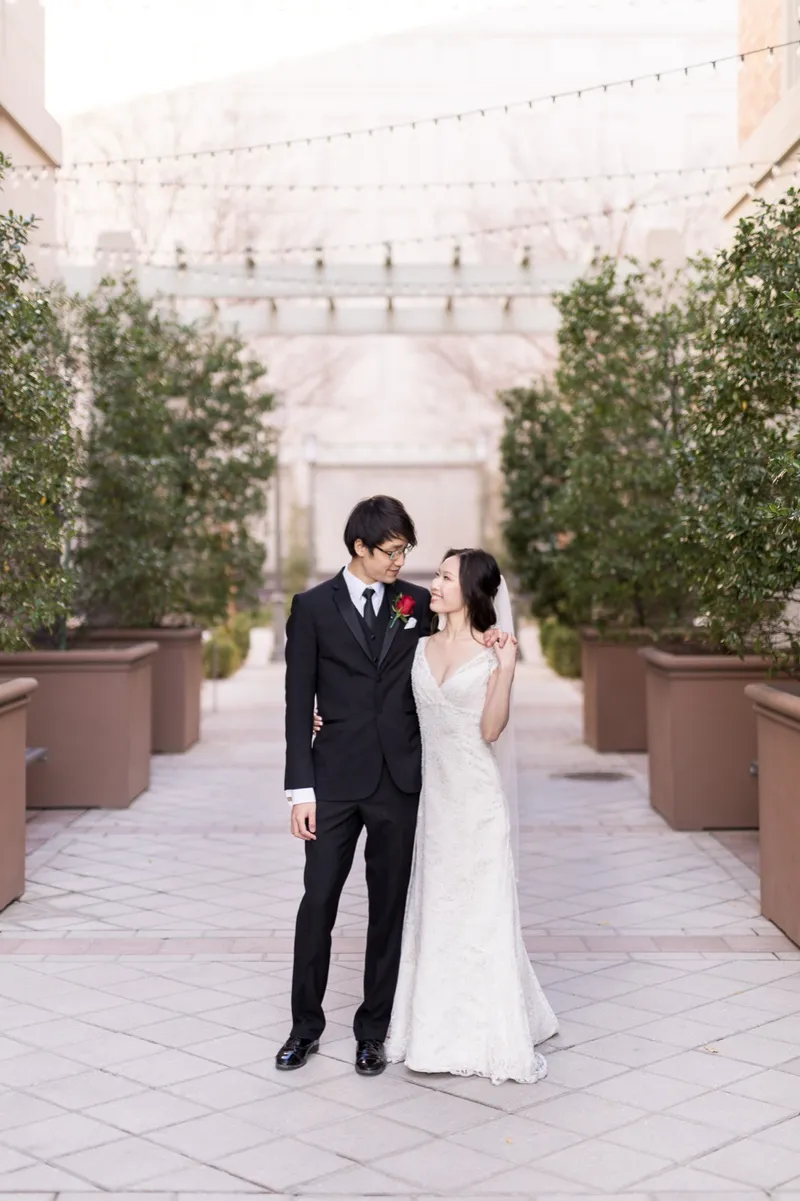 Couple walking the lit walkway close together, her hand tucked through his arm