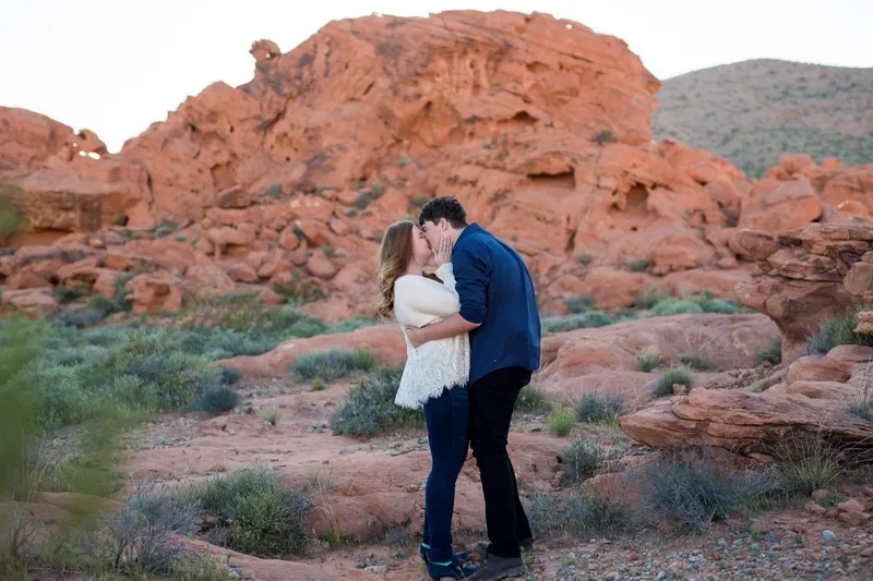 The two of them kissing just after she said yes, red sandstone filling the frame behind